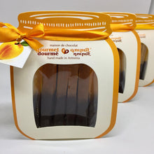 Load image into Gallery viewer, Apricot roll-up dipped in dark chocolate in a paper jar-shaped package
