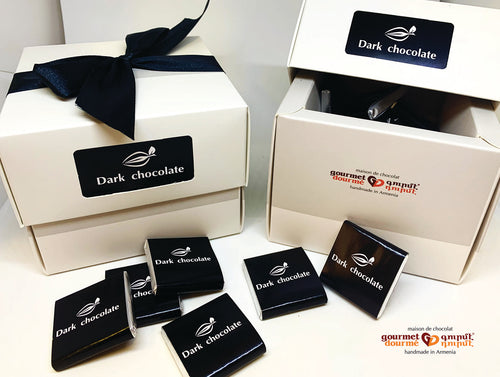 Square white box filled with dark chocolates handmade in Armenia. Wrapped with black ribbon.