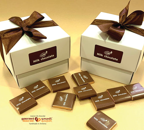 White square box filled with milk chocolate squares handmade in Armenia. Wrapped with brown ribbon.